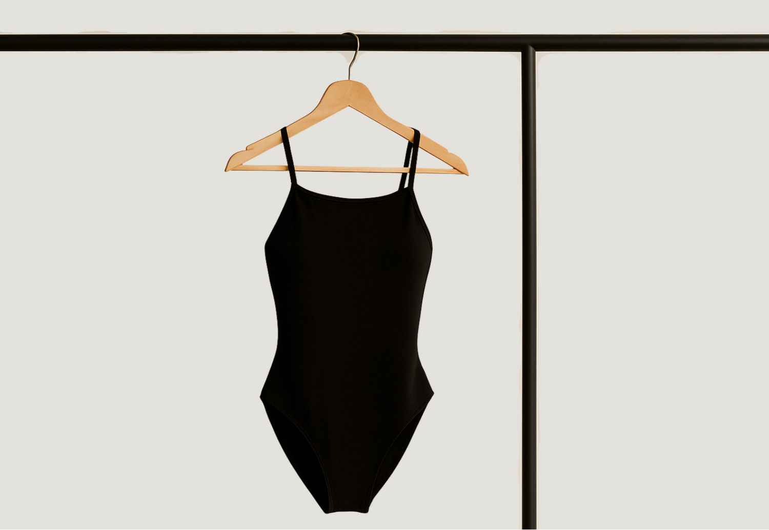 Black swimsuit on a hanger against a white background